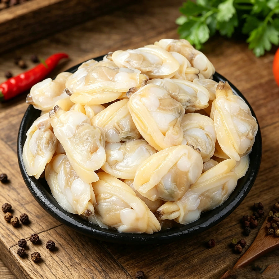 Bowl of shelled clam meat with chilli and lime on dark wood