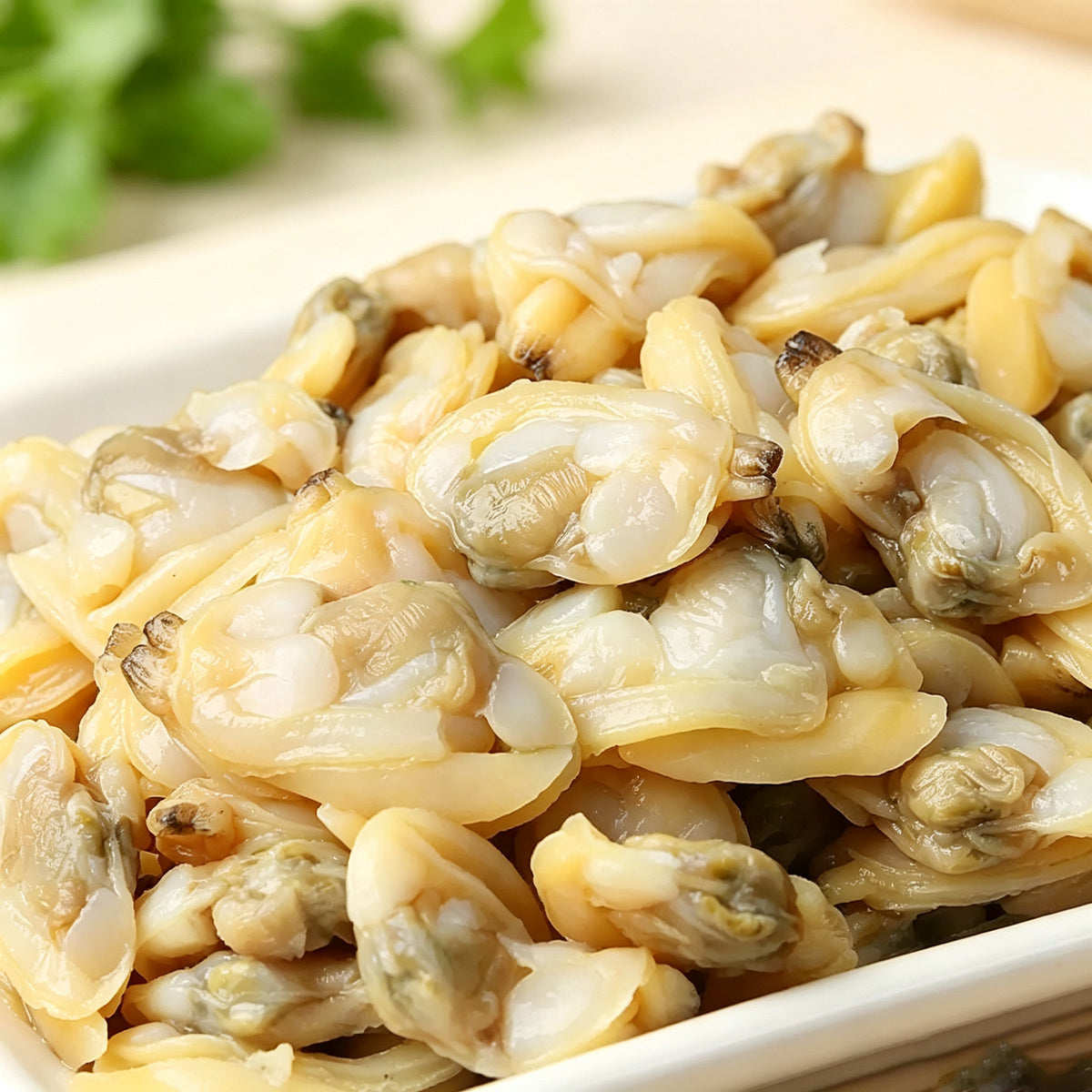 Close-up of raw shucked clam meat piled on a plate
